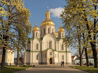 Golden domes of Saint Sophia Cathedral in Kyiv, Ukraine framed by blooming chestnut trees on a spring afternoon